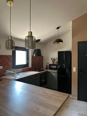 a kitchen with a black refrigerator and a counter at Le Fort 6 - Appartement neuf 6p in LʼIsle-sur-la-Sorgue