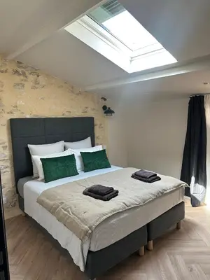 a bedroom with a large bed with green pillows at Le Fort 6 - Appartement neuf 6p in LʼIsle-sur-la-Sorgue