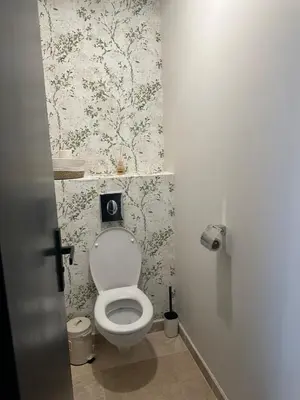 a bathroom with a toilet with floral wallpaper at Le Fort 6 - Appartement neuf 6p in LʼIsle-sur-la-Sorgue