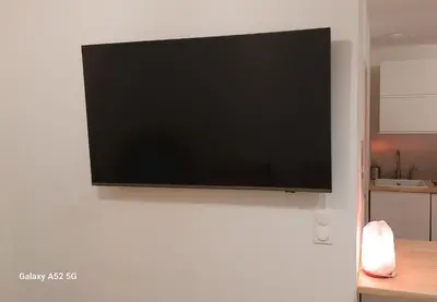 a flat screen tv hanging on a white wall at Studio MAREVA in Cavaillon