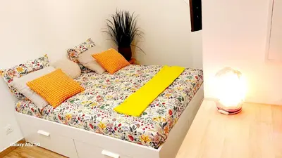 a bed with colorful pillows on it in a room at Studio MAREVA in Cavaillon