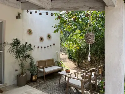 an outdoor patio with a table and chairs and a swing at Maison Luberon piscine in Viens