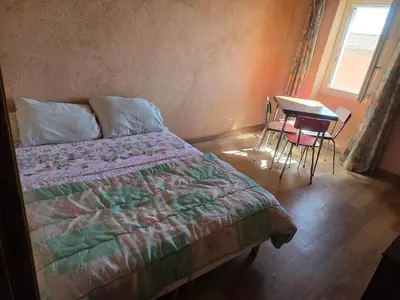a bedroom with a bed and a table and a table and chairs at Appartement Gîte d'Etape Vitrolles en Luberon in Vitrolles-en-Luberon