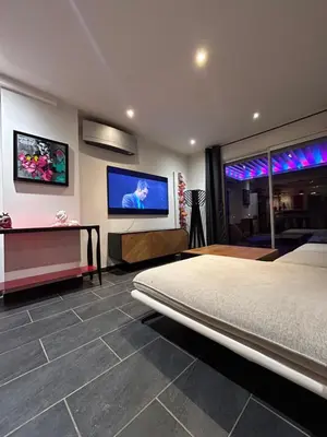 a bedroom with a bed and a flat screen tv at Maison Hélène Piano in La Tour-dʼAigues