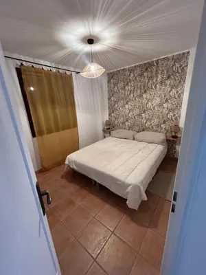 a bedroom with a white bed and a ceiling at Maison Hélène Piano in La Tour-dʼAigues