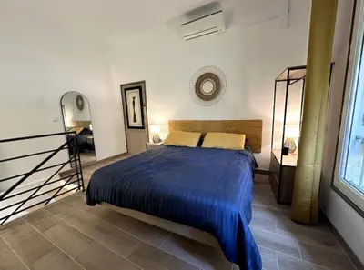 a bedroom with a bed with a blue blanket at T2 à 5mn à pieds du Cours Mirabeau in Aix-en-Provence