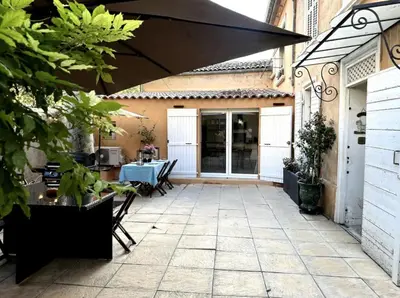 an outdoor patio with a table and an umbrella at T2 à 5mn à pieds du Cours Mirabeau in Aix-en-Provence