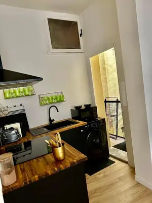 a kitchen with a counter and a sink and a stove at CARPENTRAS 2ème étage BEL APPARTEMENT au CENTRE VILLE in Carpentras