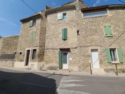 an old stone building with green shutters on a street at Village House in Pélissanne near Luberon in Pélissanne
