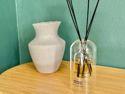 a vase and a bottle on a wooden table at Refuge reposant - Centre ville - Espace Bureau in Aix-en-Provence