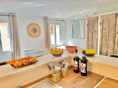 a kitchen with a counter with bottles of wine and bread at Refuge reposant - Centre ville - Espace Bureau in Aix-en-Provence