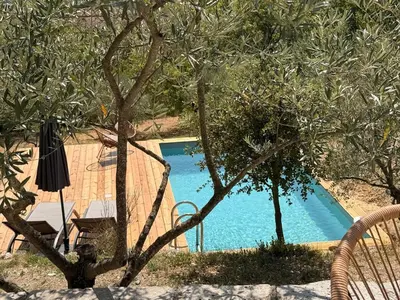 a swimming pool in front of a house with trees at Bastidon avec vue et piscine au coeur du Luberon in Céreste