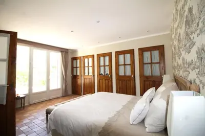 a bedroom with a large white bed and windows at Les Carrairades in Mollégès