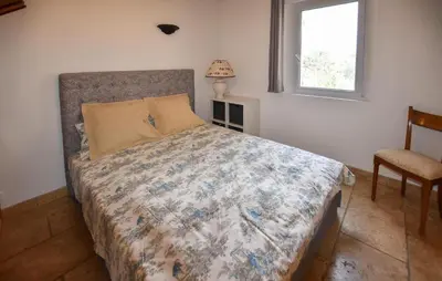 a bedroom with a bed and a window at Maison Avec Piscine Privée in Lacoste