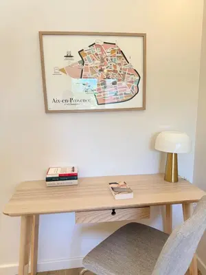 a wooden desk with a lamp and a picture on the wall at Le Quatre Relax in Aix-en-Provence