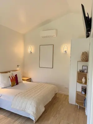 a bedroom with a bed and two lights on the wall at Cozy studio with air conditioning & pool & parking in Aix-en-Provence