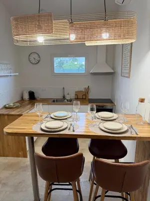 a wooden table with chairs and plates and wine glasses at Escapade Provençale 5 in Aix-en-Provence