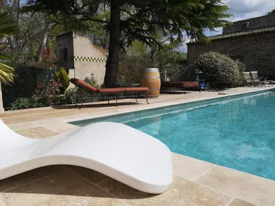 a white chair sitting next to a swimming pool at Mas D'Ange en Provence in Les Taillades