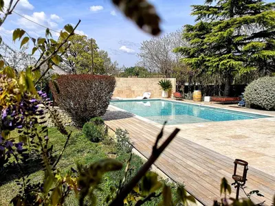 a swimming pool in a yard with a wooden deck at Mas D'Ange en Provence in Les Taillades