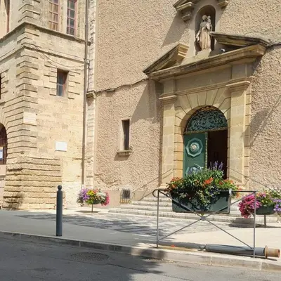 a building with a door with flowers in front of it at Studio cosy proche d Aix en Provence climatisé in Éguilles