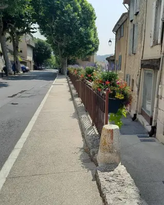 a sidewalk with flowers on the side of a street at Studio cosy proche d Aix en Provence climatisé in Éguilles