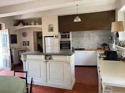 a kitchen with white cabinets and a counter top at Il était une fois à Lagnes in Lagnes