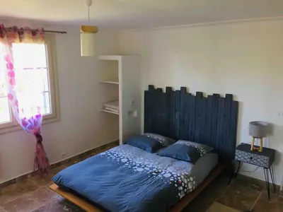 a bedroom with a bed with blue sheets and a window at Gîte ,studio dans le village de lagnes in Lagnes