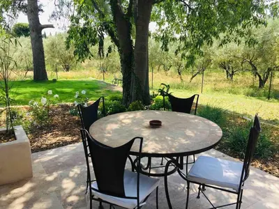 a patio table and chairs with a view of a park at Gîte ,studio dans le village de lagnes in Lagnes