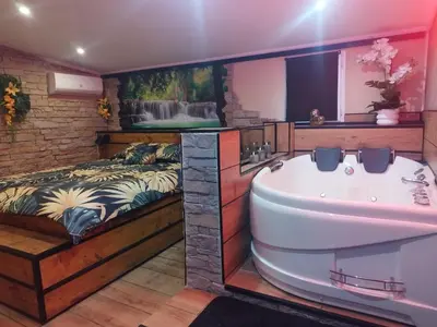 a bathroom with a bed and a tub next to a sink at Casa Lova Spa Privé, Clim,Baignoire balnéo in Entraigues-sur-la-Sorgue