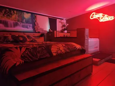 a bedroom with a bed in a red room at Casa Lova Spa Privé, Clim,Baignoire balnéo in Entraigues-sur-la-Sorgue