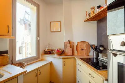 a kitchen with yellow cabinets and a window at Splendide appartement au cœur du centre historique in Aix-en-Provence