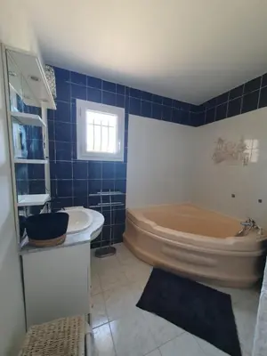 a blue tiled bathroom with a tub and a sink at Évasion provençale in Saint-Cannat