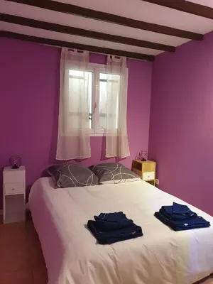 a bedroom with a white bed with purple walls at Évasion provençale in Saint-Cannat