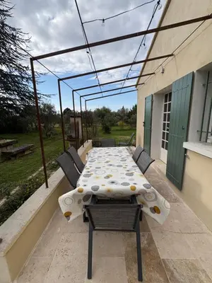 a patio with a table and chairs on a balcony at le mas au pied du Ventoux in Carpentras