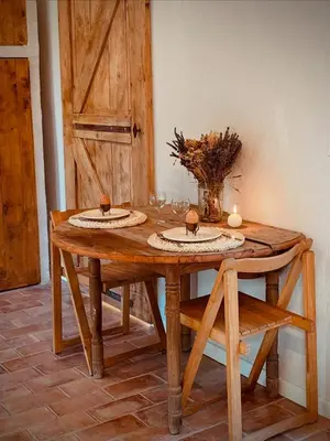 a wooden table with two plates and candles on it at Le mazet du cavalier in Puyvert
