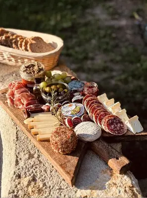 a tray of meats and cheese and bread on a table at Le mazet du cavalier in Puyvert
