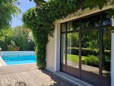 a house with a large glass door next to a swimming pool at La Canopée en Provence - Piscine, Vue sur le Mont Ventoux ! in Carpentras