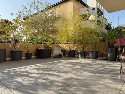 a patio with chairs and potted plants in front of a building at studio calme campagne in Aix-en-Provence