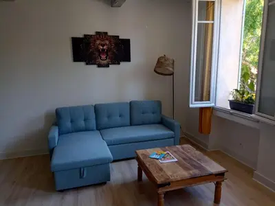 a living room with a blue couch and a table at L'escale Cavaillonnaise in Cavaillon
