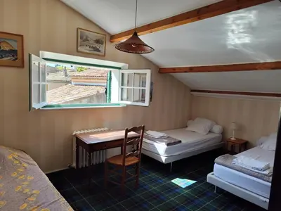 a room with two beds and a desk and a window at Vaste villa , piscine , garage pour vélos et motos , grand parking in Caromb
