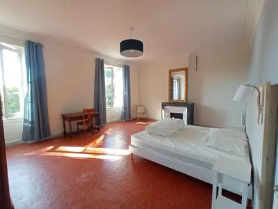 a bedroom with a bed and a desk and windows at Maison de famille dans les amandiers Provence 15 prs - Domaine de Ribbe in Rognes