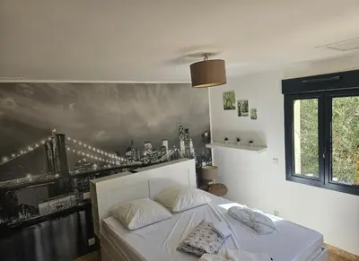 a bedroom with a bed with a painting on the wall at Les oliviers in Saint-Didier