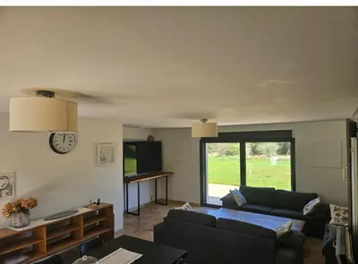 a living room with a couch and a tv at Les oliviers in Saint-Didier
