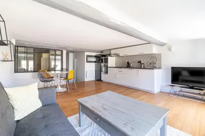 a living room with a couch and a table at Aixora - Centre historique - Tout à pied & parking in Aix-en-Provence