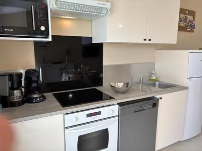 a kitchen with a white stove top oven next to a sink at Petite maison à 2 pas du centre de Bédoin in Bédoin