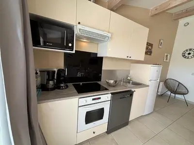 a kitchen with white cabinets and a stove top oven at Petite maison à 2 pas du centre de Bédoin in Bédoin