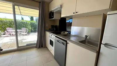a kitchen with a sink and a table with a patio at Petite maison à 2 pas du centre de Bédoin in Bédoin
