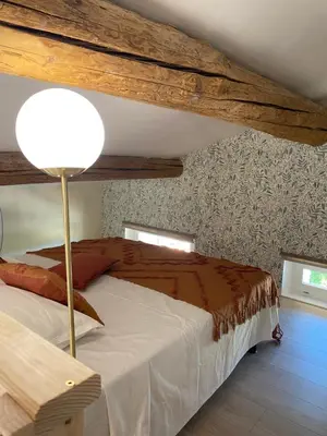 a bedroom with a bed with a lamp in it at L appartement Lambescain in Lambesc