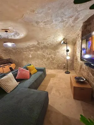 a living room with a couch and a tv at Luxe & Volupté sous les Voûtes d'Aix centre ville in Aix-en-Provence