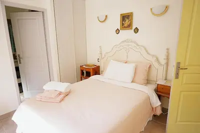 a bed with a wooden nightstand next to a bed with a white bed at LaPetite Maison Abigail, Peaceful home in Avignon in Avignon